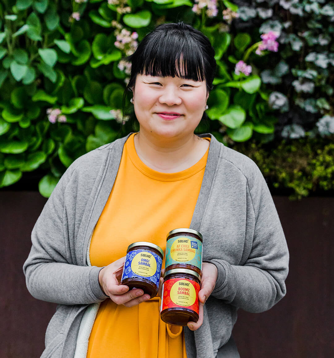 Holly Ong, co-founder of Sibeiho   Holding three of their signature sambals. 